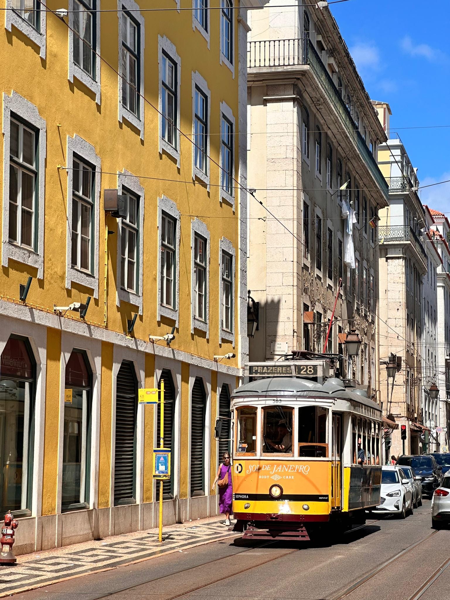 Yellow Tram next to yellow building in Lisbon