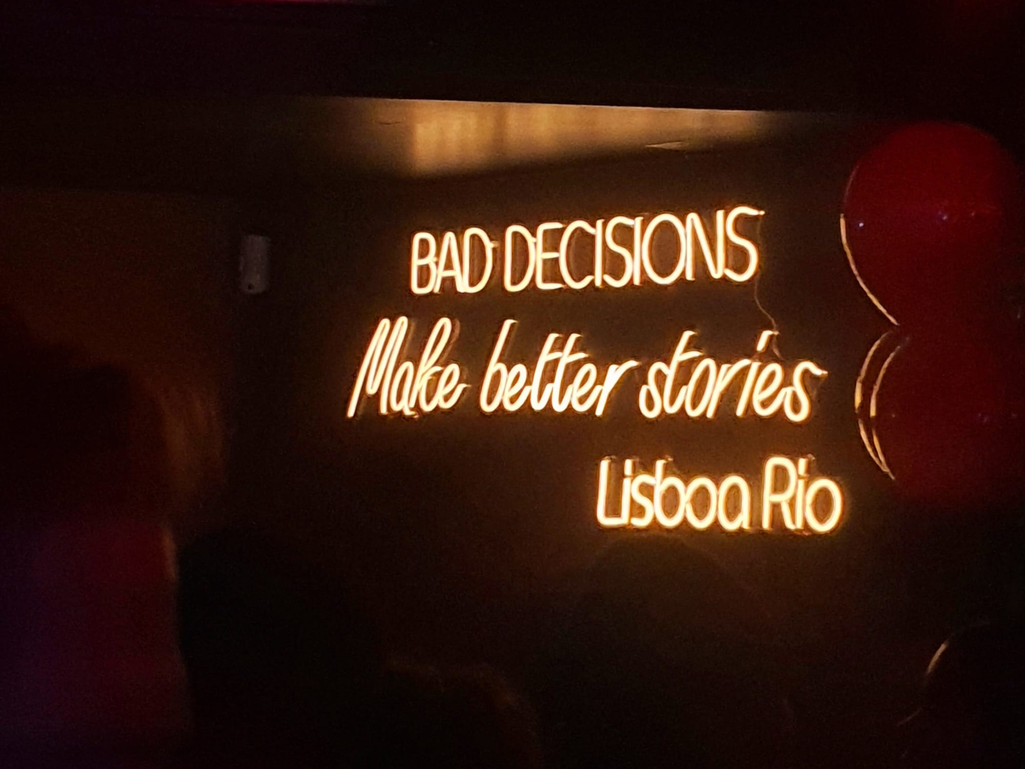 Letrero de neón 'Bad Decisions Make Better Stories' en Lisboa Rio